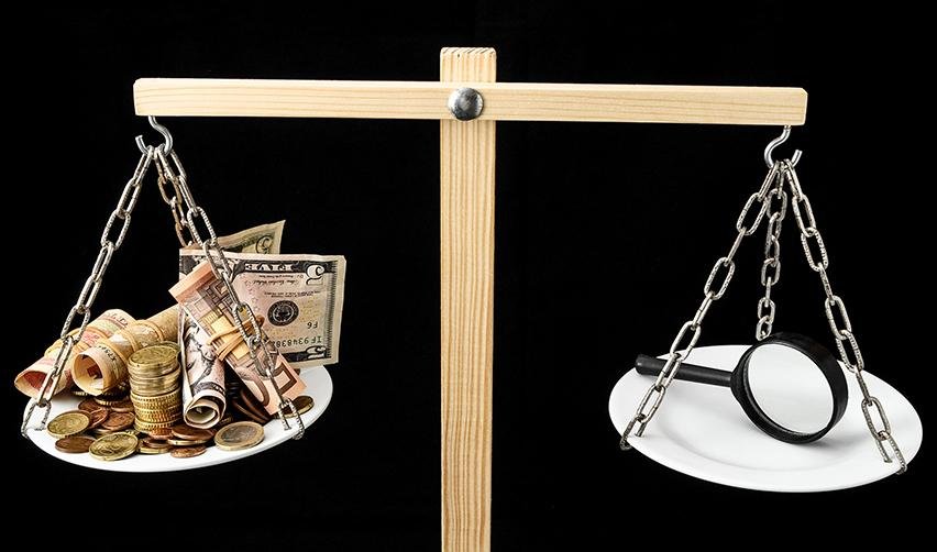 Investment funds representing the EB5 minimum investment amount and a magnifying glass on either side of a wooden scale.
