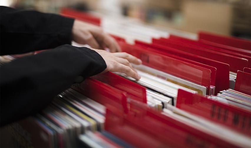 A national visa center officer's hands searching through a stack of files and documents.