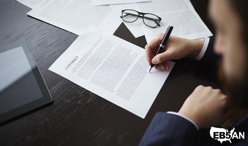 An EB5 investor signing some contract documents related to their rural TEA investment for fast green card processing, above the EB5AN logo.