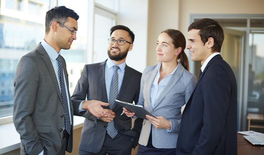Group of business professionals networking and discussing EB5 project strategies, showcasing the importance of staying connected with EB5 industry leaders.