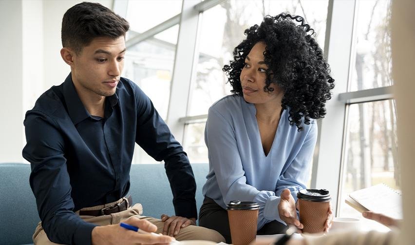 A focused discussion between two individuals planning EB5 investment strategies, highlighting the importance of expert guidance in the EB5 program.