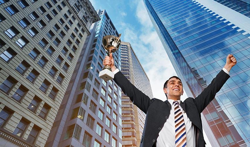 A triumphant businessman holding a trophy amidst a backdrop of urban buildings. This symbolizes achieving US permanent residency through the EB5 program and succeeding in the American business landscape.