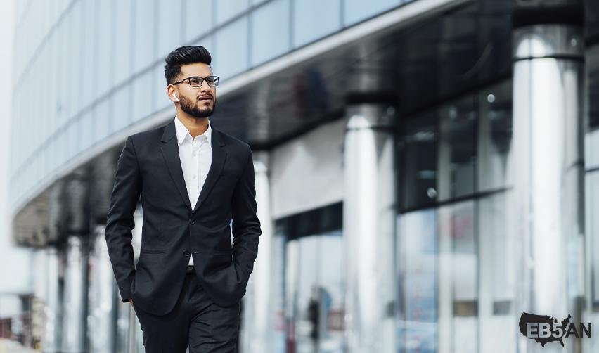 The EB5AN logo next to a professional businessman walking outside a modern office building, representing career opportunities for EB5 investors in America.