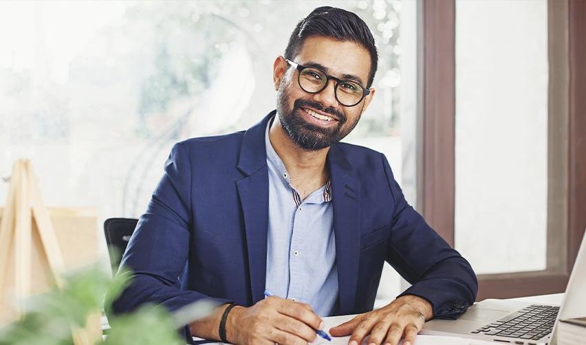 An Indian EB5 investor works at his desk, representing skilled immigrants navigating U.S. immigration policy changes that impact employment and residency options.