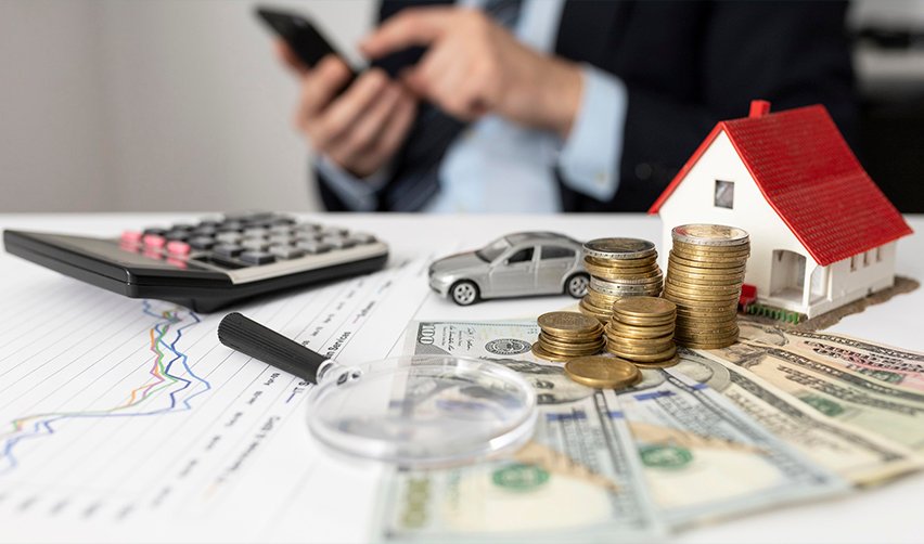 Financial planning concept with coins, calculator, house model, and investment charts for EB5 projects, especially highlighting the role of real estate developers in mixed-use development.