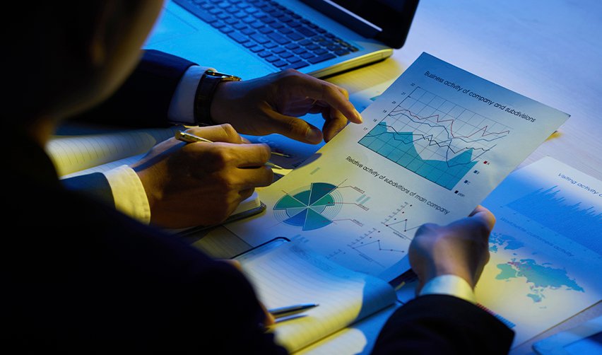 Investor analyzing financial data and business charts, evaluating the track record of regional center projects for successful EB5 investment.