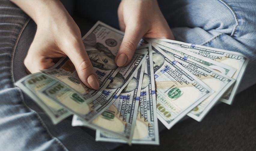 Investor holding U.S. dollars, reflecting reduced capital investment requirements for EB5 rural projects.