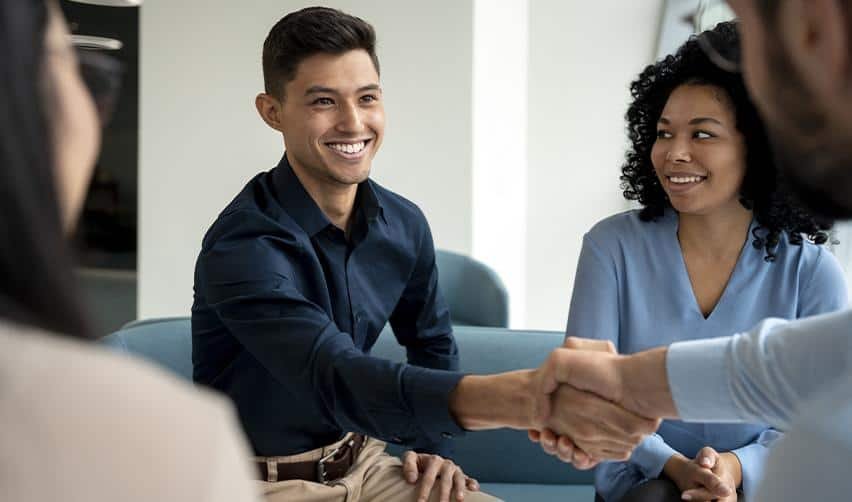 Smiling professionals shaking hands during an EB5 consultation meeting, representing trust and partnership in U.S. immigration investment planning.