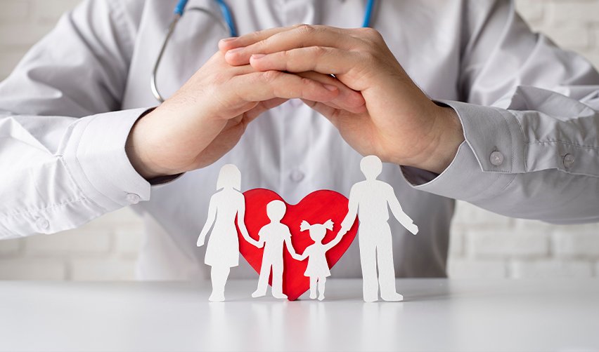 A doctor or healthcare professional shielding a paper cutout family with his hands, symbolizing U.S. healthcare access and safety for EB5 investors.