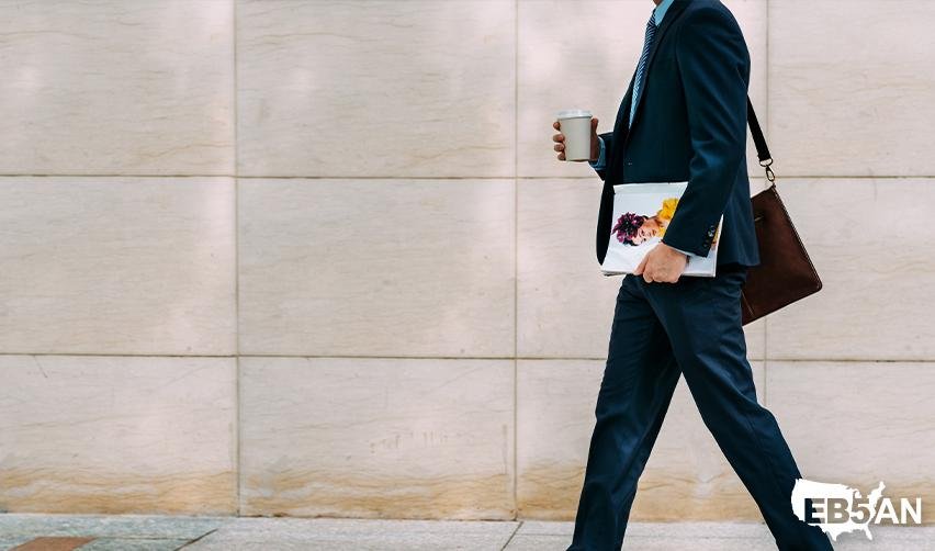 A business owner or CEO walking on the street, with the EB5AN logo on the corner, symbolizing the career opportunities that an EB5 green card offers.