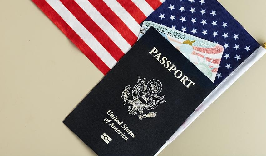 An American passport with a Green Card in it, symbolizing how EB5 can help foreign nationals obtain permanent residency and eventual citizenship in the United States.