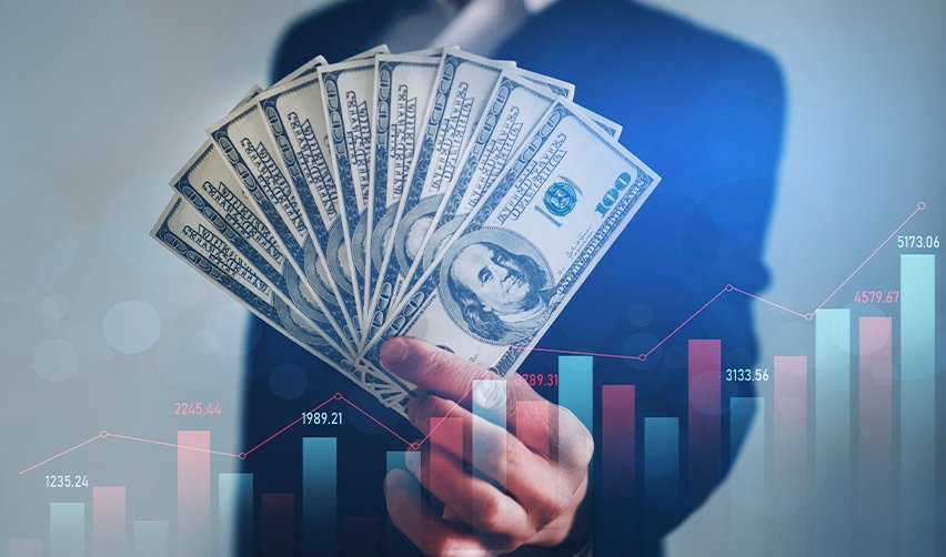 Hand holding dollar bills in front of financial graph. Visual representation of EB5 investment strategy using U.S. earnings and financial planning.