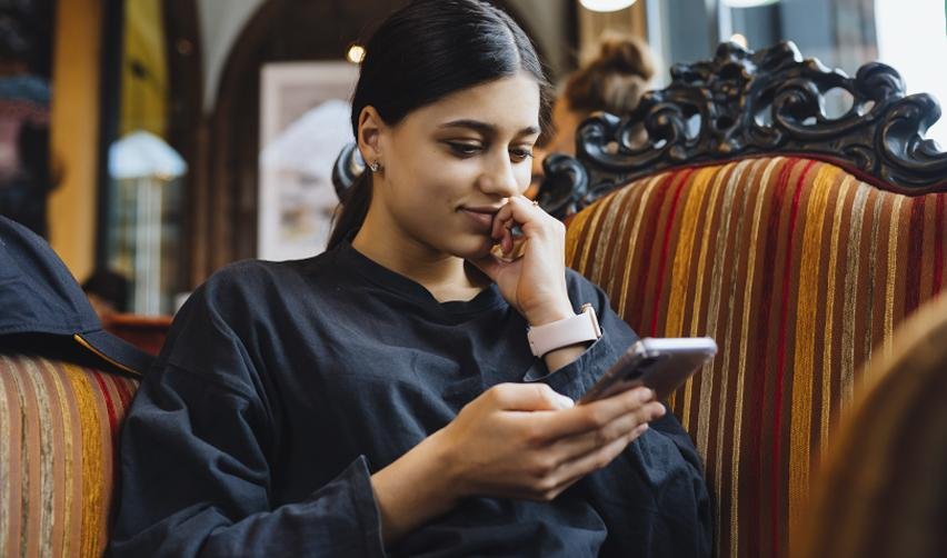 An EB5 investor on her phone, checking the state department's monthly visa bulletin for July 2025.