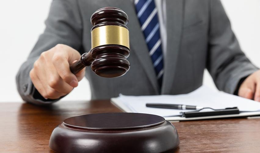 A close-up of a judge’s gavel about to strike, symbolizing USCIS adjudication trends and EB5 petition approvals.
