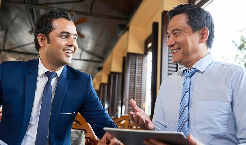 Indian and East Asian business professionals meeting with a tablet, representing EB5 investors discussing visa backlogs, set-aside categories, and U.S. immigration strategy.